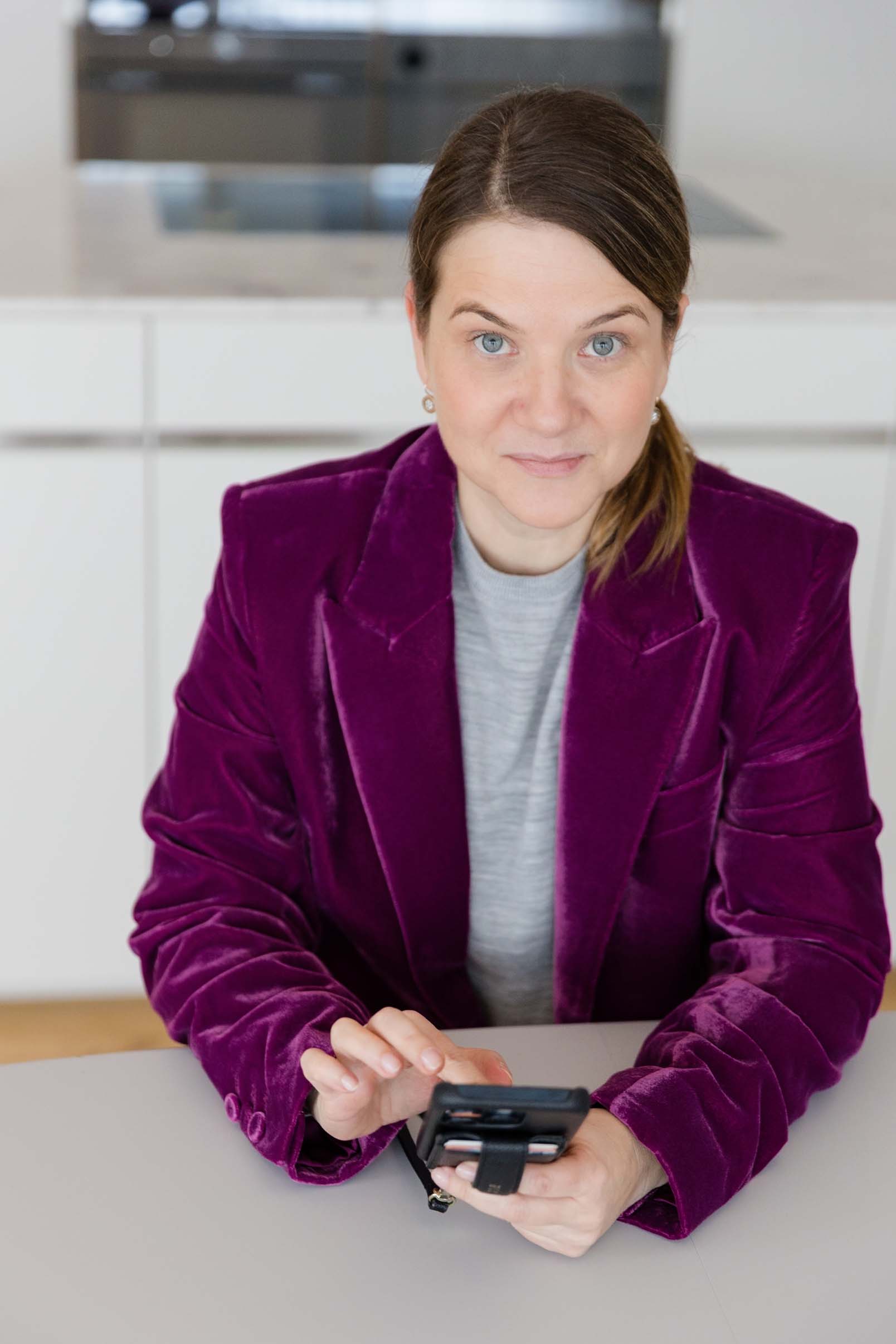 Frau mit Telefon am Tisch